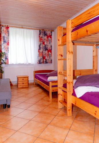 a bedroom with two bunk beds and a window at -Waldhaus-Fewo 4 in Granzow