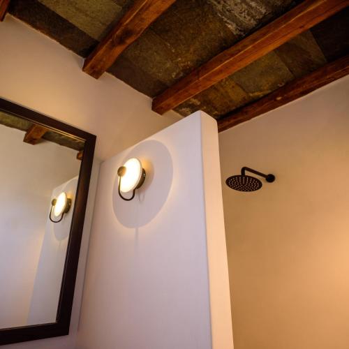 a room with two lights on the wall and a mirror at Seascape Suites Folegandros in Ano Meria