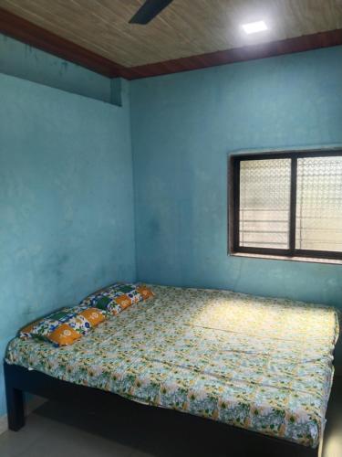 a bedroom with a bed in a room with a window at Shreya Cottage, Vaishet-Alibag in Vaishet