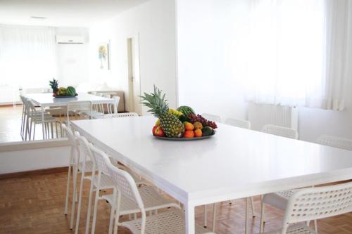 a white table with a bowl of fruit on it at Freshness Modern 2 Bedroom Apartment with Balcony & Stunning Sea View in Central Limassol in Limassol