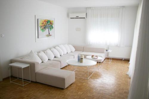 a living room with a white couch and a table at Freshness Modern 2 Bedroom Apartment with Balcony & Stunning Sea View in Central Limassol in Limassol