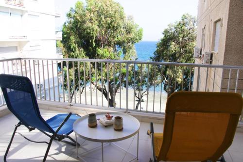 a balcony with a table and two chairs and the ocean at Freshness Modern 2 Bedroom Apartment with Balcony & Stunning Sea View in Central Limassol in Limassol