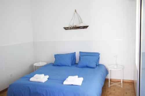a bedroom with a blue bed with two towels on it at Freshness Modern 2 Bedroom Apartment with Balcony & Stunning Sea View in Central Limassol in Limassol