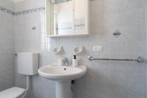 a white bathroom with a toilet and a sink at Garden - residence in the center of Barzio in Barzio