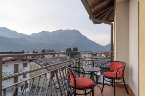 a balcony with two chairs and a table with a view at Garden - residence in the center of Barzio in Barzio