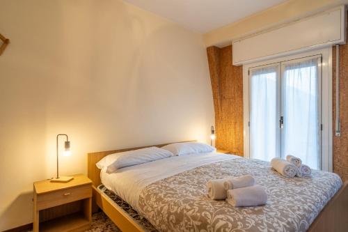 a bedroom with a large bed with towels on it at Garden - residence in the center of Barzio in Barzio
