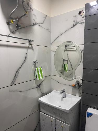 een witte badkamer met een wastafel en een spiegel bij Phoenix Wedding & HomeStay in Amritsar