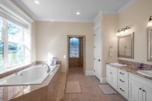 a large bathroom with a tub and two sinks at Luxurious 4-Bedroom Oasis with Private Pool in Seguin