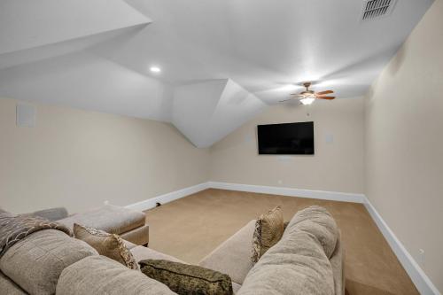 a living room with a couch and a flat screen tv at Luxurious 4-Bedroom Oasis with Private Pool in Seguin