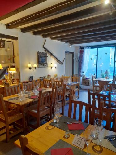un restaurant avec des tables et des chaises en bois et des fenêtres dans l'établissement Hôtel du Centre, à Villard-de-Lans