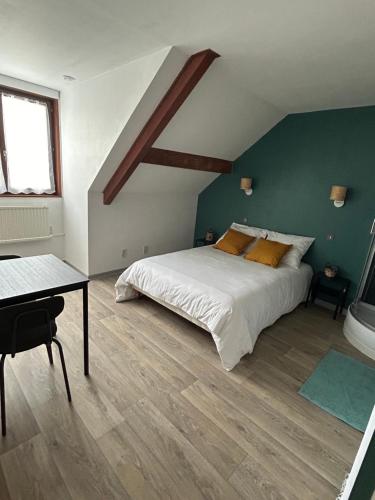 une chambre avec un lit et une table dedans dans l'établissement Les Bords de la Lizaine, à Héricourt