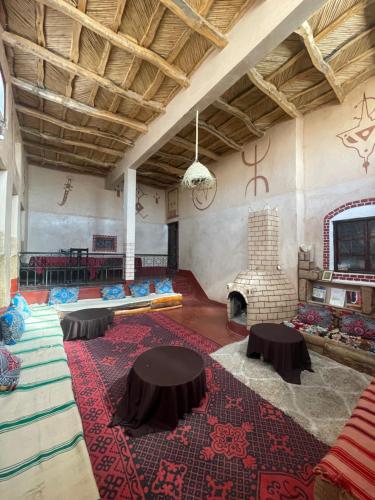 a large room with a fireplace and a table and chairs at Dar Laayoune in Kalaat MGouna
