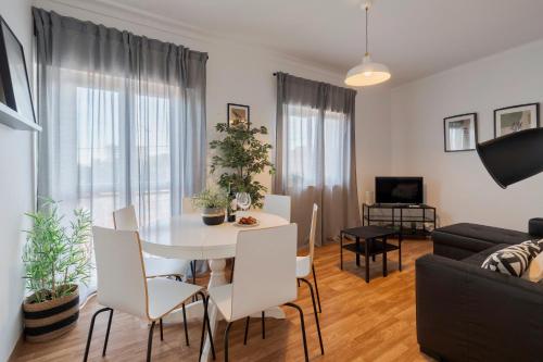 a living room with a white table and chairs at Casa Verde - By Y Concept in Setúbal