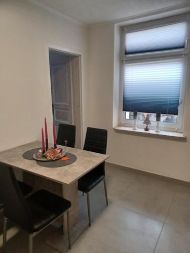 a dining room with a table and chairs and a window at Ferienwohnung Julie in Weißwasser
