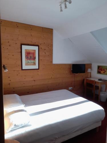 - une chambre avec un lit blanc et un mur en bois dans l'établissement Hôtel du Centre, à Villard-de-Lans