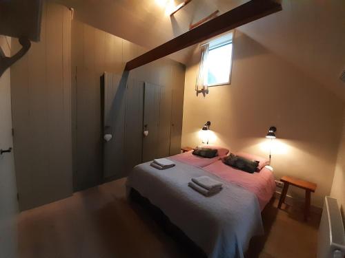a bedroom with a bed with two towels on it at Gastenverblijf Lheederhof Lodge 3 in Dwingeloo