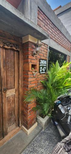 a brick building with a door and a sign on it at Jineng Guest house in Dalung