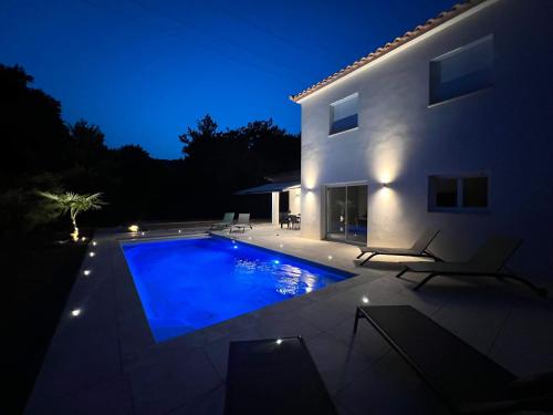 une piscine devant une maison la nuit dans l'établissement Casamea - Villa Familiale, Piscine, 15 min Ajaccio, à Alata