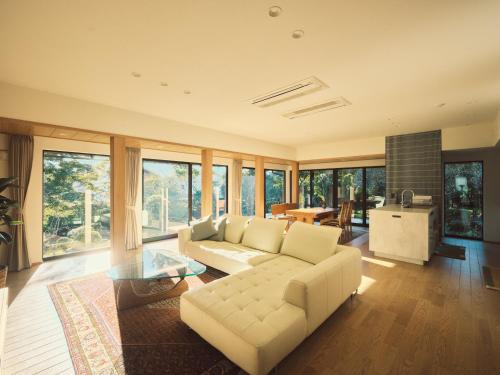 a living room with a white couch and a table at Cottage LALA GARDEN in Kumamoto