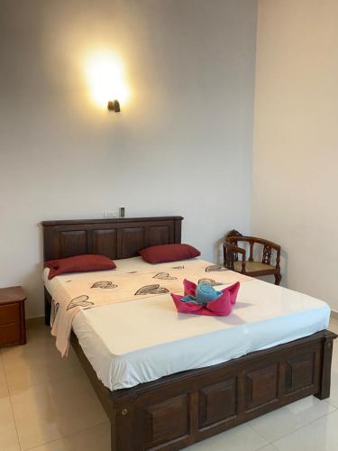 a bed with a pink bow on top of it at Massimo Hotel Weligama in Weligama