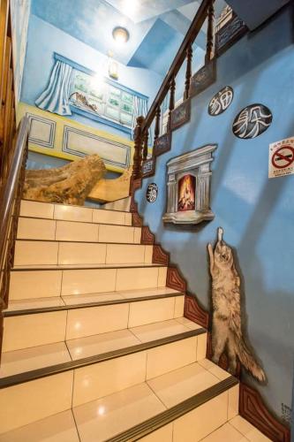 a staircase in a house with a cat sitting on it at Gui Ren Sha Cheng Guest House in Chenggong