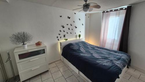 - une chambre avec un lit et une fenêtre avec des oiseaux sur le mur dans l'établissement Maison de village en Provence verte, à Sainte-Anastasie-sur-Issole