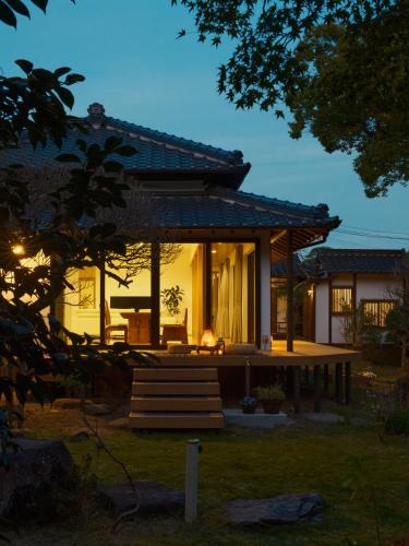 a house with a porch and stairs in front of it at Cottage LALA GARDEN in Kumamoto