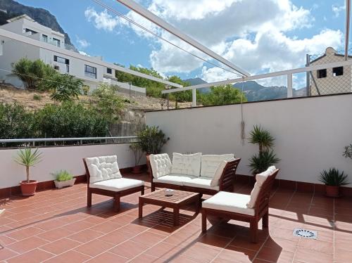 a patio with two chairs and a table on a balcony at Apartamentos entreRíos in Cazorla
