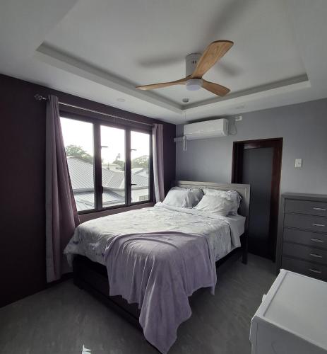 a bedroom with a bed with a ceiling fan at Emerald at SAGE in Bon Accord