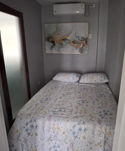 a small bedroom with a bed with a bedspread at Emerald at SAGE in Bon Accord