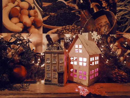 a toy house on a table with christmas decorations at Hotel Au Nom De Dieu in Dilsen-Stokkem