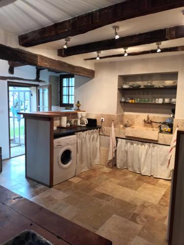 une cuisine avec une machine à laver dans une pièce dans l'établissement AUBERGE dans LES GORGES DE L'AVEYRON, à Varen