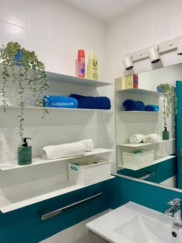 a bathroom with a sink and shelves with towels at Mi Oasis Azul Parking, AC, Fibra, VT-54949-V in Sueca