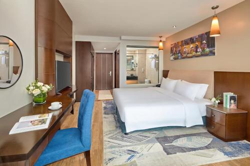 a hotel room with a large bed and a desk at The Hanoi Club Hotel & Residences in Hanoi