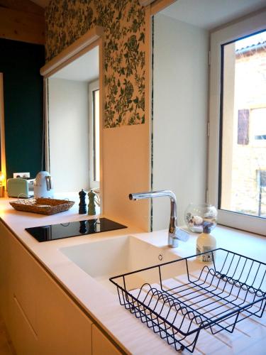 - un évier de cuisine avec un étendoir à vaisselle dans l'établissement Le Nid d Aulesaje, à Ville-sur-Jarnioux