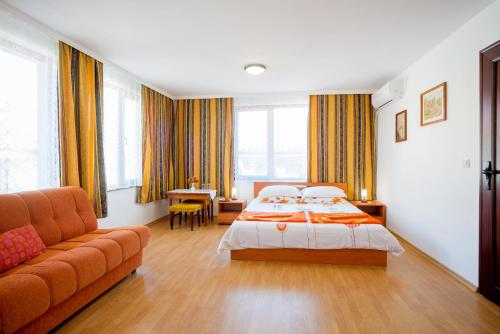 ソゾポルにあるGuest House Tulenのベッドとソファ付きのホテルルーム