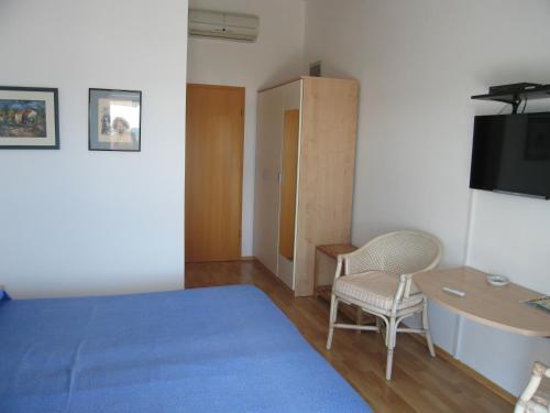 a bedroom with a blue bed and a table and chair at room 1 in Pula