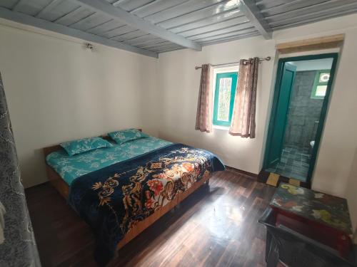 a bedroom with a bed in the corner of a room at The Eleventh homestay in Kasol