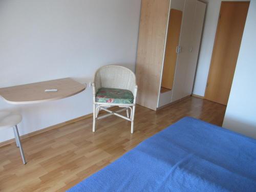 a room with a chair and a table and a blue rug at room 1 in Pula