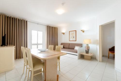 a living room with a table and a couch at Atlantida by Garvetur in Quarteira