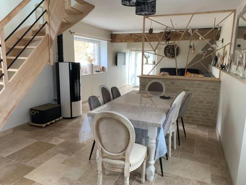 une cuisine et une salle à manger avec une table et des chaises dans l'établissement Les Racines, à Chailloué