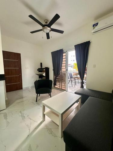 a living room with a ceiling fan and a table at D&L Apartment in Bayahibe