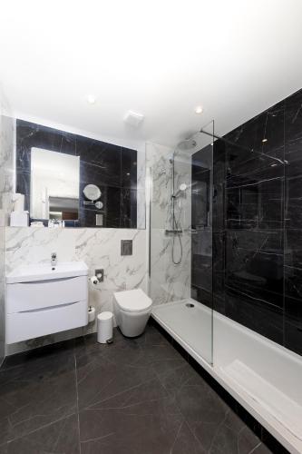 a bathroom with a toilet and a sink and a shower at Dover Marina Hotel & Spa, Tapestry Collection by Hilton in Dover