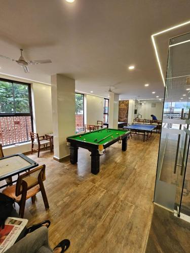 a room with a pool table and several tables at SKYLINE CoLive in Hyderabad