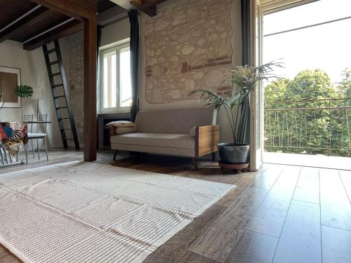a living room with a couch and a large window at Holyday Luxury Apartment with Jacuzzi Tub in Verona