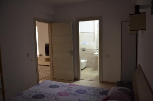 a bedroom with a door leading to a bathroom at Bujorului Residence - 2Br Apartament Central in Craiova