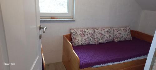 Habitación pequeña con sofá púrpura y ventana en Green idyll Sarajevo, en SJJ