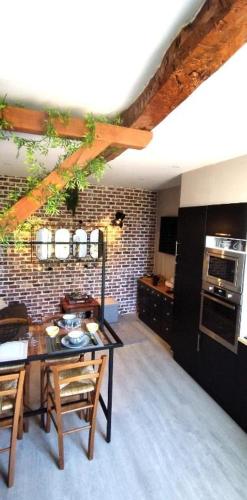 une cuisine avec une table et des chaises dans une pièce dans l'établissement Maison de village Cosy, à Villelongue-de-la-Salanque