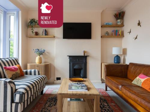 a living room with a couch and a fireplace at The Lorelei 2BR Mid-Century Modern Stylish Apartment in Brighton & Hove