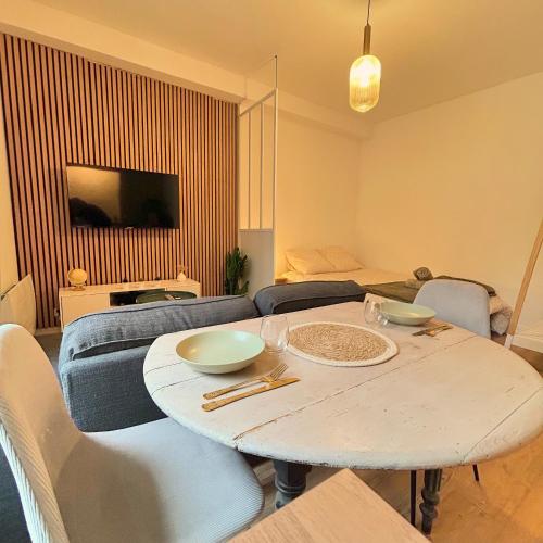 un salon avec une table et un canapé dans l'établissement Appartement Résidence Lenoir - Centre REIMS, à Reims